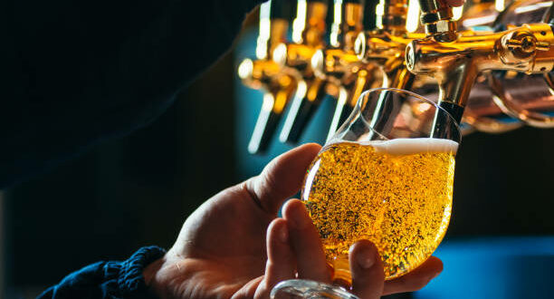 Close up of bartender pouring draft beer in glass