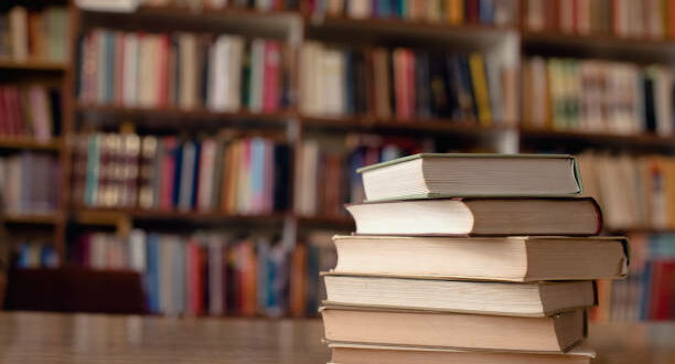 Close up of books on desk in library.